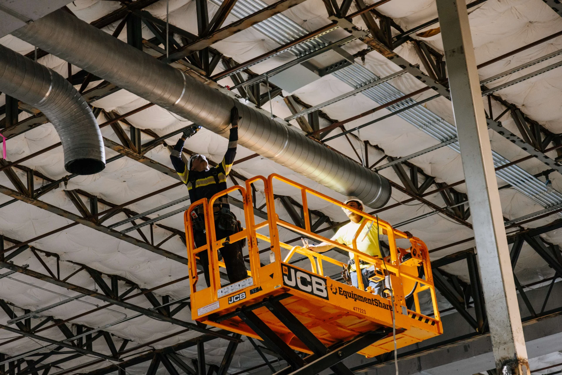 Crews working on a lift installing vents in the Worship Center